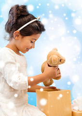 Image showing smiling little girl with gift box and teddy bear