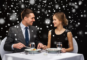 Image showing smiling couple eating main course at restaurant