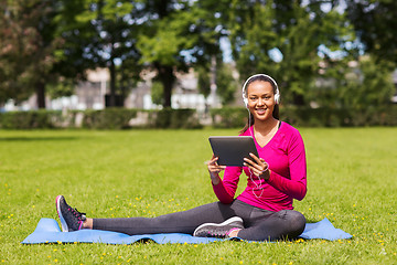 Image showing smiling woman with tablet pc outdoors