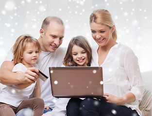 Image showing happy family with laptop computer and credit card