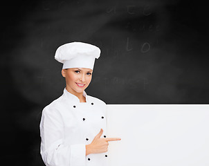 Image showing smiling female chef with white blank board