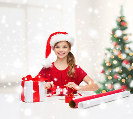 Image showing smiling girl in santa helper hat with gift box