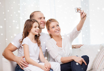 Image showing happy family with camera taking picture at home