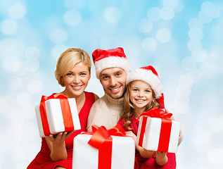 Image showing happy family in santa helper hats with gift boxes