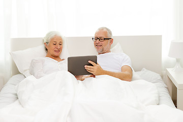 Image showing happy senior couple with tablet pc at home