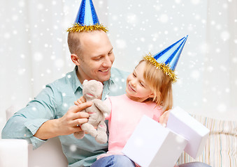 Image showing father and daughter in party caps with gift box