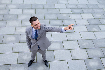 Image showing young smiling businessman outdoors from top