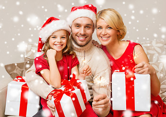 Image showing smiling family holding many gift boxes