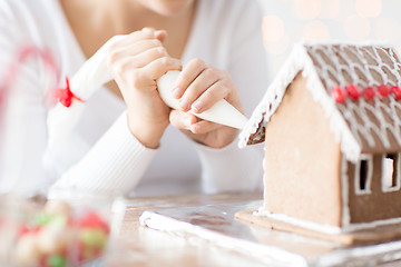 Image showing close up of woman making gingerbread house at home