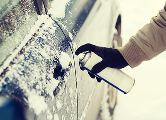 Image showing closeup of man hand with lock door de-icer