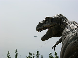 Image showing Dinosaur eating an airplane