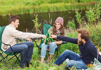 Image showing group of smiling tourists drinking beer in camping