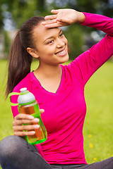 Image showing smiling teenage girl showing bottle