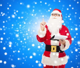 Image showing man in costume of santa claus with notepad