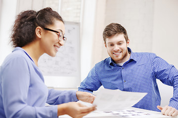 Image showing smiling team with paper at office