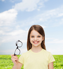 Image showing smiling cute little girl holding black eyeglasses