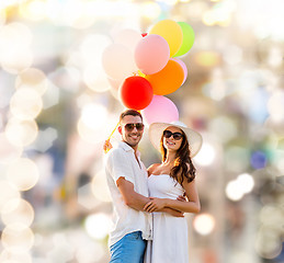 Image showing smiling couple with air balloons outdoors