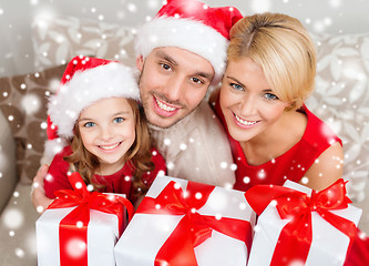 Image showing smiling family holding many gift boxes