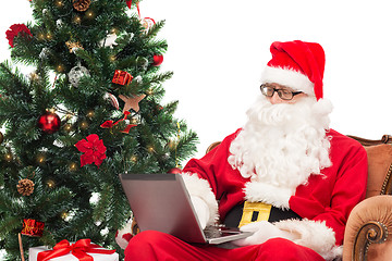 Image showing man in costume of santa claus with laptop