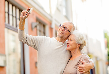 Image showing senior couple photographing on city street