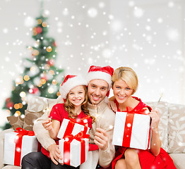 Image showing smiling family holding many gift boxes