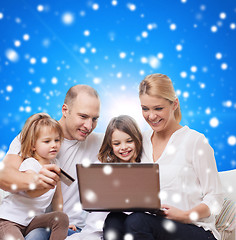 Image showing happy family with laptop computer and credit card