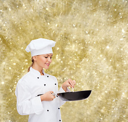 Image showing smiling female chef with pan and spoon