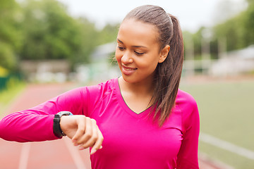 Image showing smiling woman running on track outdoors