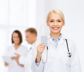 Image showing smiling female doctor with pills