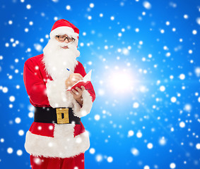 Image showing man in costume of santa claus with notepad