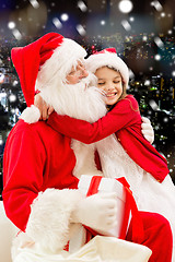 Image showing smiling little girl with santa claus and gifts