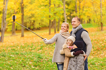 Image showing happy family with smartphone and monopod in park