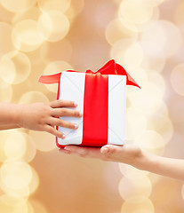 Image showing close up of child and mother hands with gift box