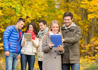 Image showing group of smiling friends with tablets in park
