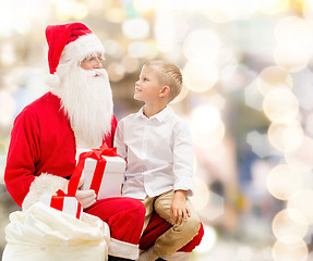 Image showing smiling little boy with santa claus and gifts