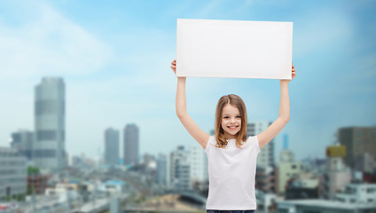 Image showing smiling little girl holding blank white board