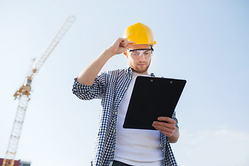 Image showing builder in hardhat with clipboard outdoors