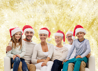 Image showing happy family in santa helper hats sitting on couch