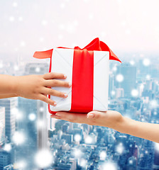 Image showing close up of child and mother hands with gift box