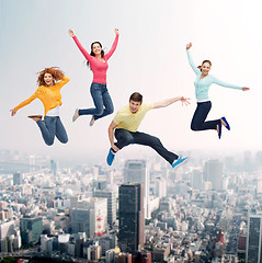 Image showing group of smiling teenagers jumping in air
