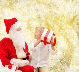 Image showing smiling little boy with santa claus and gifts