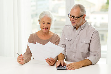 Image showing senior couple with papers and calculator at home