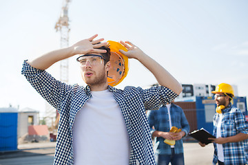 Image showing group of builders in hardhats outdoors