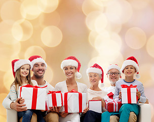 Image showing happy family in santa helper hats with gift boxes