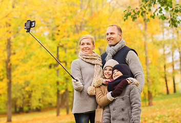 Image showing happy family with smartphone and monopod in park