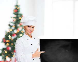 Image showing smiling female chef with white blank board