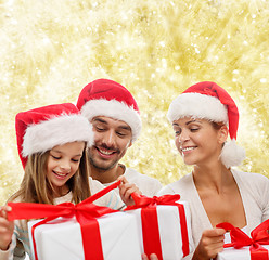 Image showing happy family in santa helper hats with gift boxes