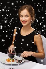 Image showing smiling woman with tablet pc eating main course