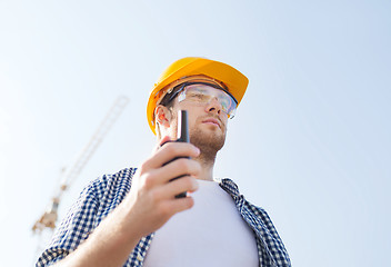 Image showing builder in hardhat with radio