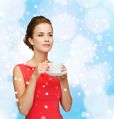 Image showing smiling woman in red dress with cup of coffee